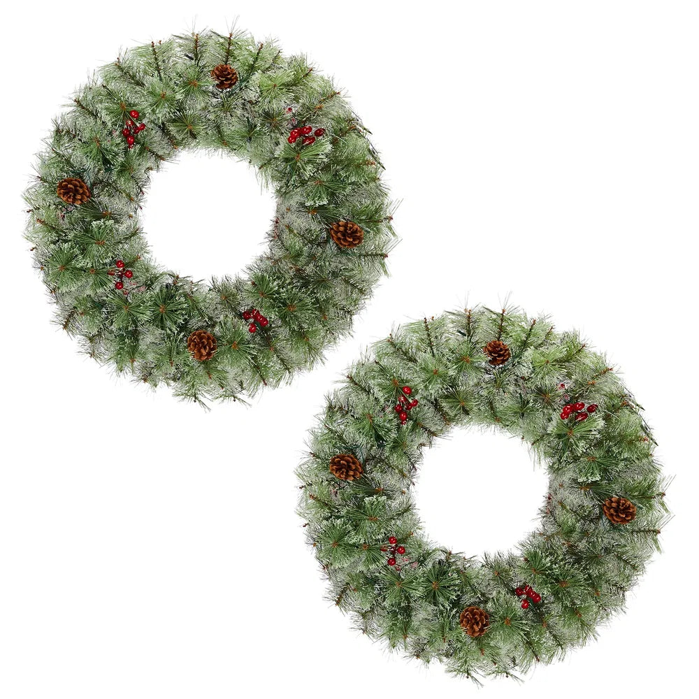 Two lit Christmas wreaths on a front door
