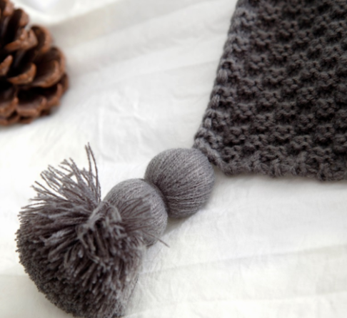 Waffle knit throw with pom-pom fringe