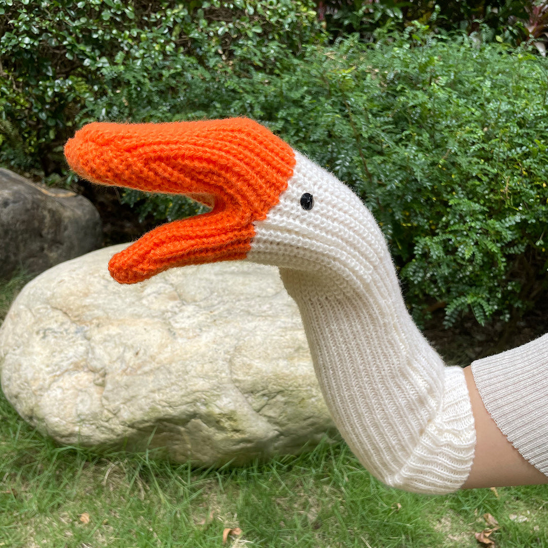 Knitted white goose mittens with orange beaks