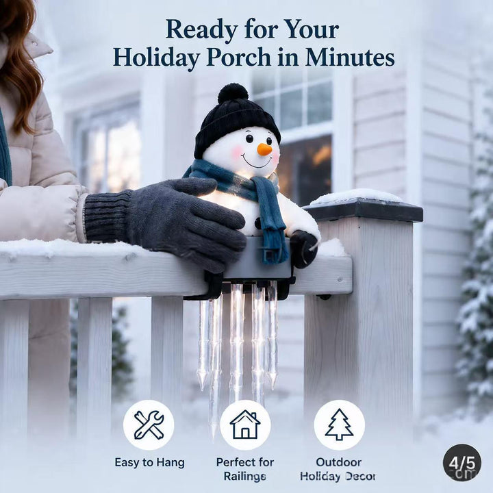 Lit snowman figure sitting on a ledge with hanging icicles