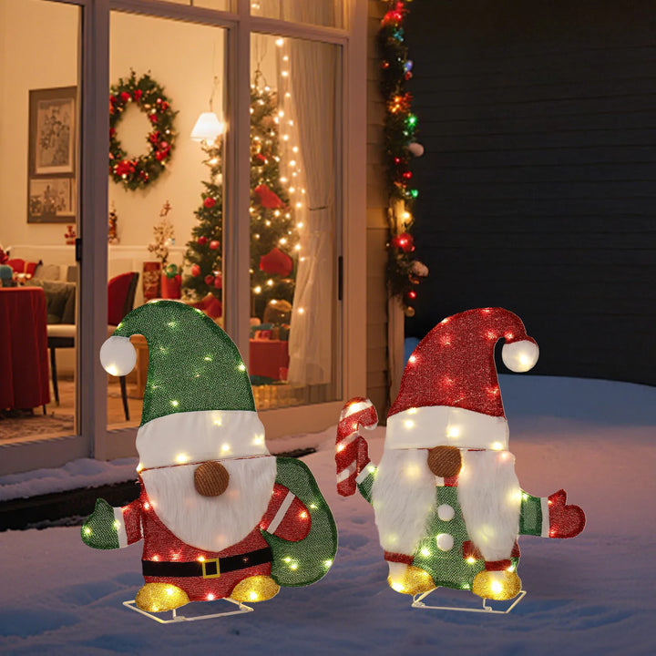 Two lighted Christmas gnomes in a yard