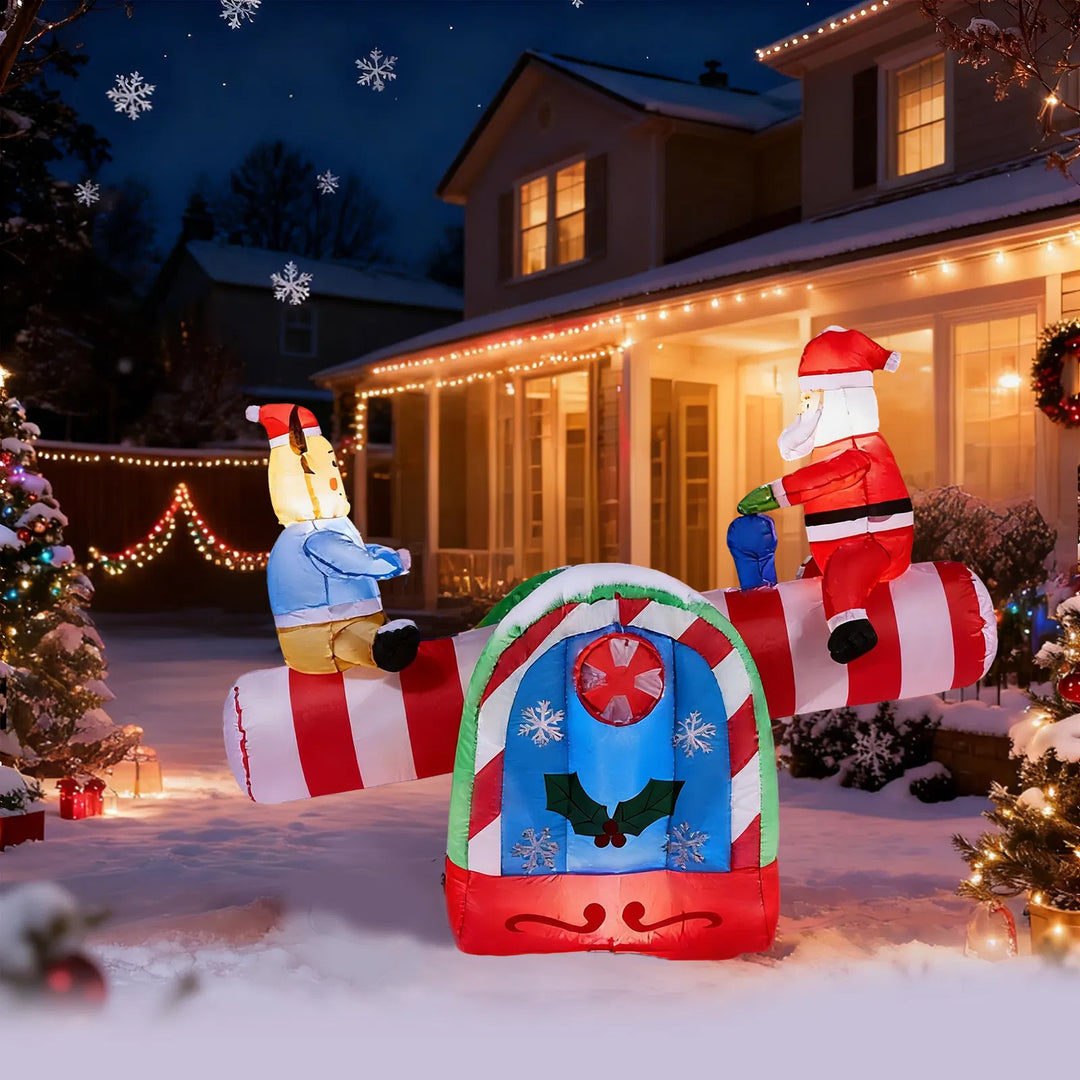 Inflatable Santa and reindeer seesaw lit at night
