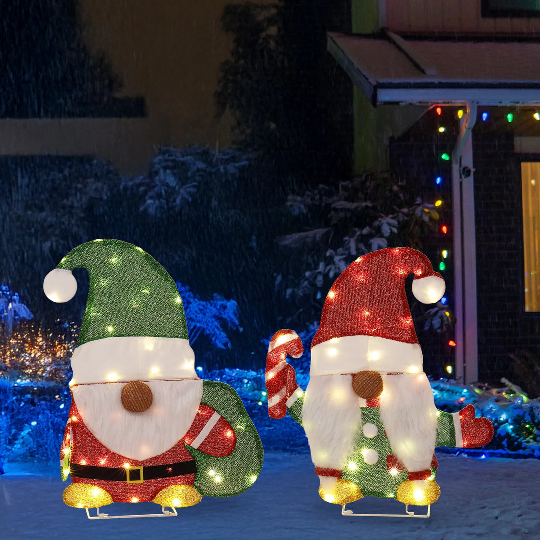 Two lighted Christmas gnomes in a yard