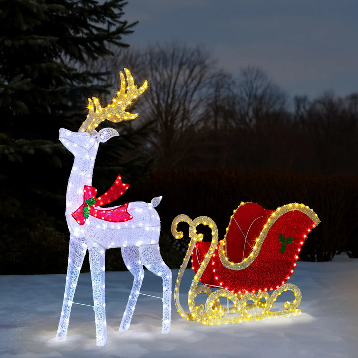 Lighted reindeer and sleigh at night