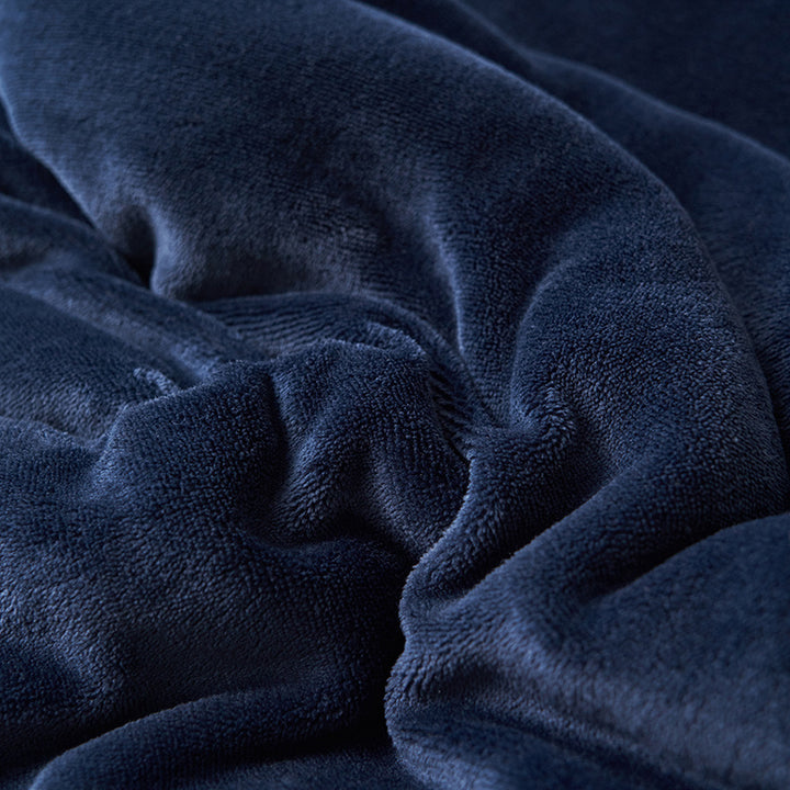 Reversible sherpa throw on a bed