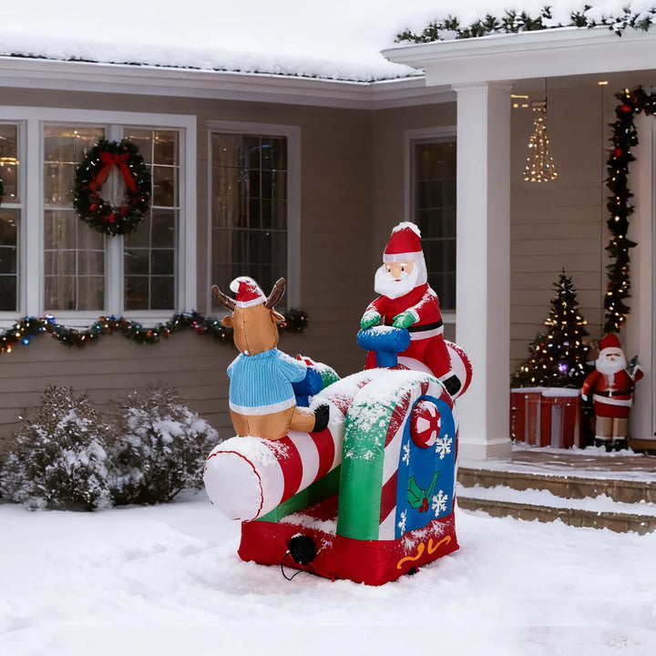 Inflatable Santa and reindeer seesaw lit at night
