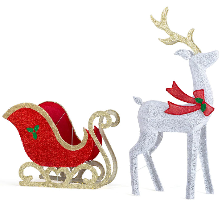Lighted reindeer and sleigh at night