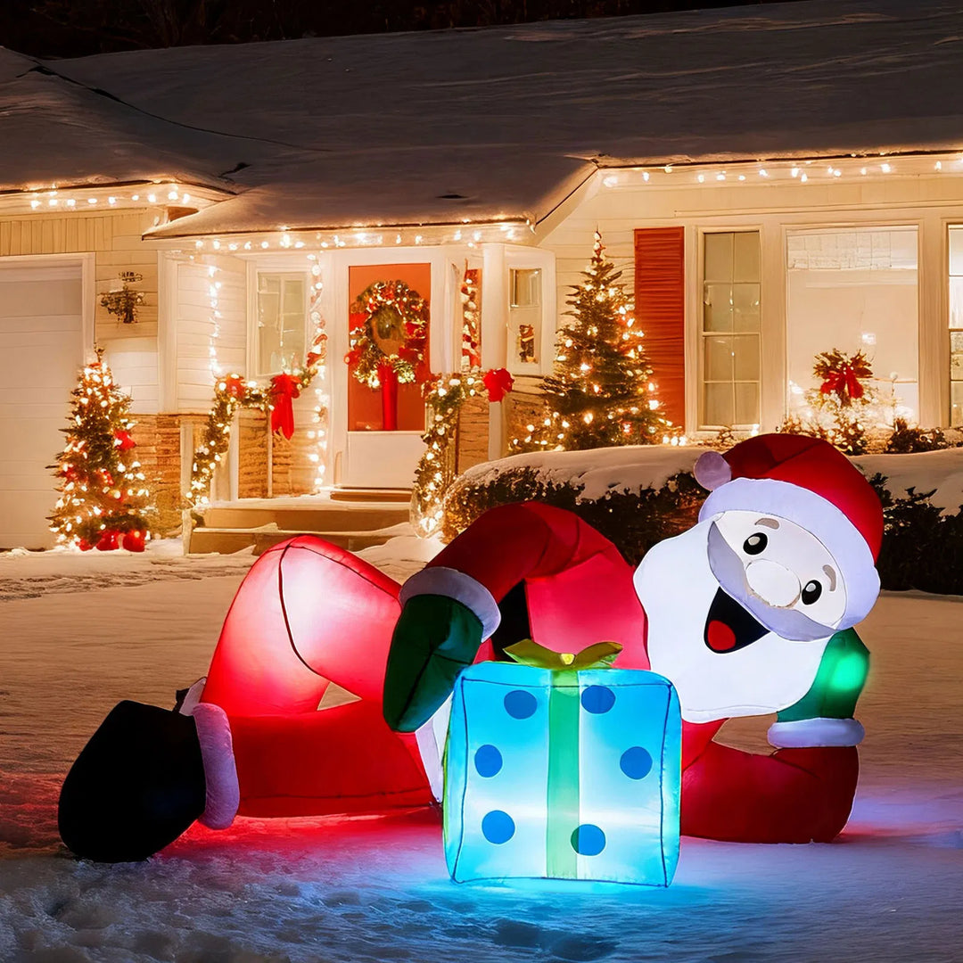 Inflatable Santa lying on lawn with gift