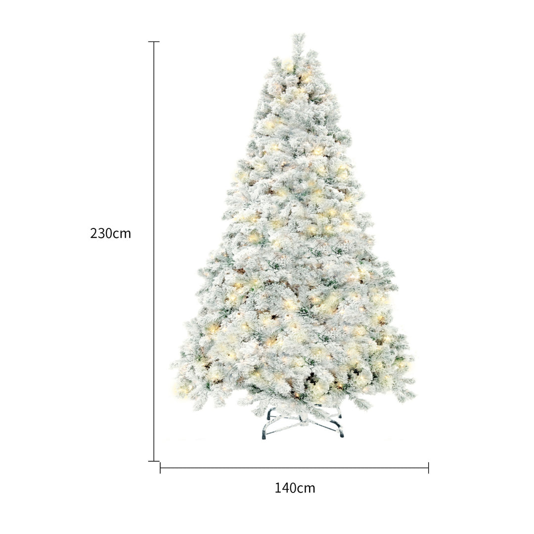 Snow-flocked white Christmas tree with warm-white lights